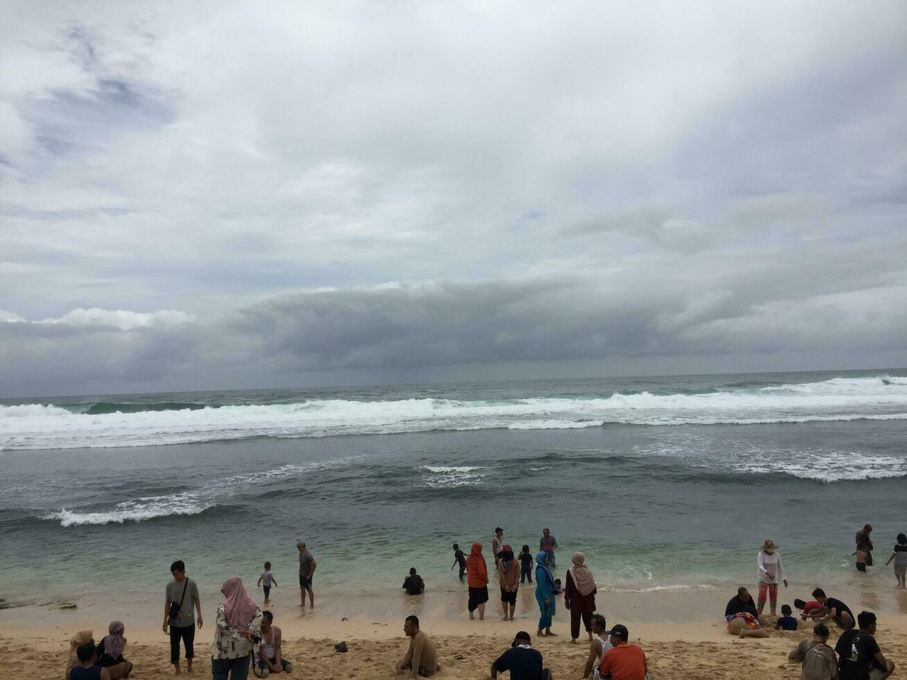 lokal- turister spela på slili strand foto