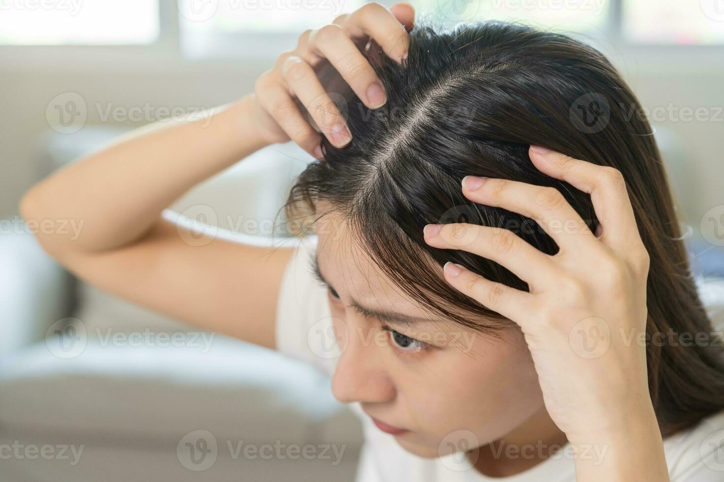 skadad hår, ansikte allvarlig asiatisk ung kvinna oroa ser på skalp i spegel, hand i ha sönder in i främre hår förlust, tunn problem symptom på Hem. hälsa vård schampo skönhet, isolerat på bakgrund. foto