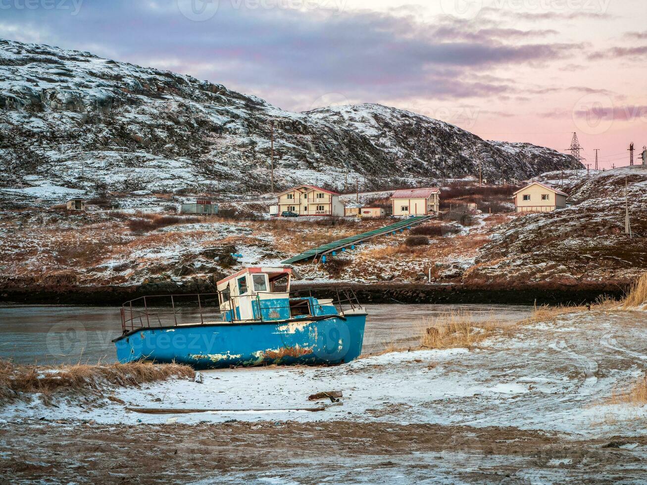 ett gammal rostig fiske båt övergiven förbi en storm på de Strand. kyrkogård av fartyg, gammal fiske by på de Strand av de barents hav, de kola halvö, teriberka foto