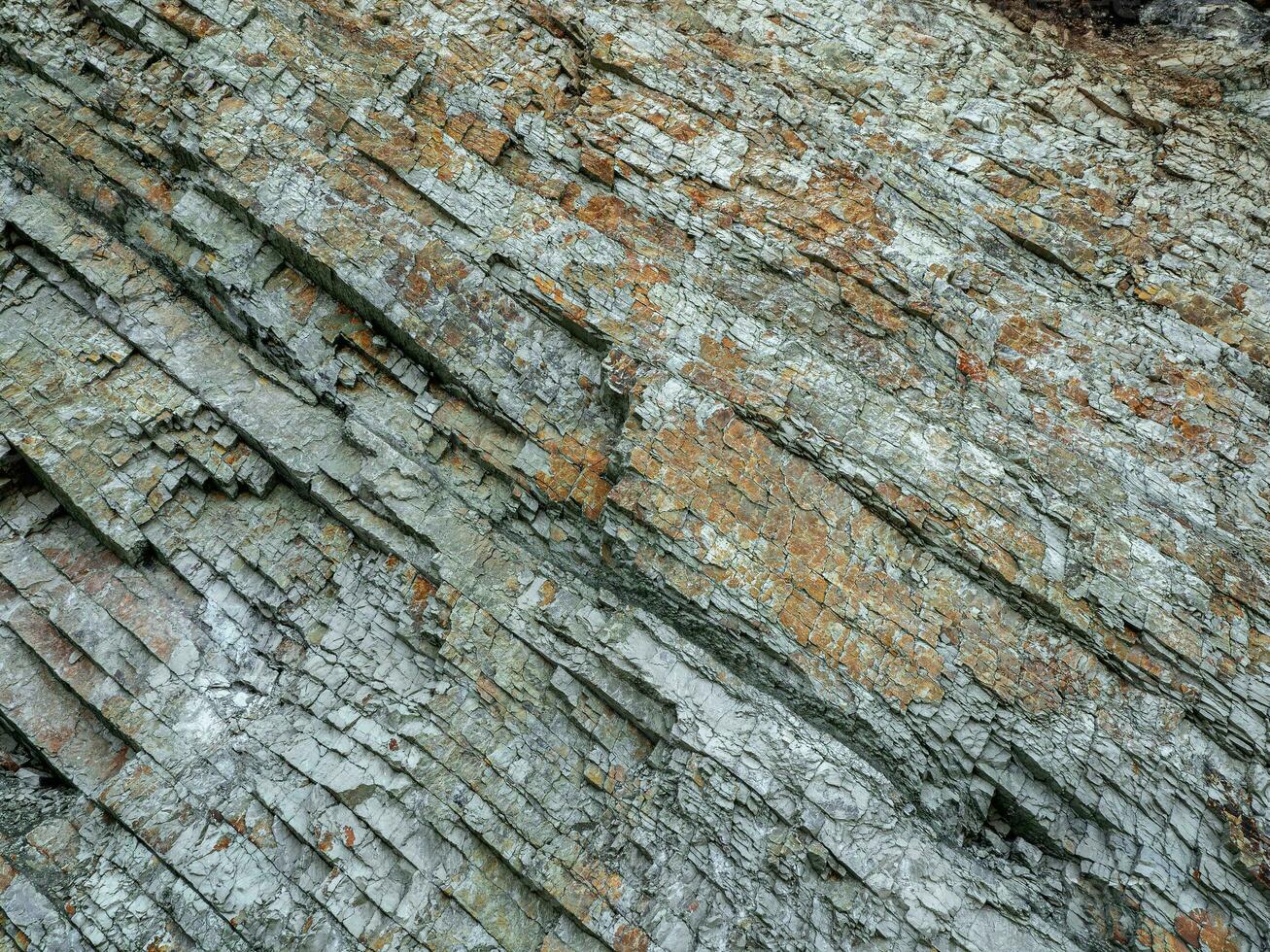 korsa sektion av rocks. geologisk skikten. färgad skikten av stenar i sektion av de montera, annorlunda sten formationer och jord skikten. foto