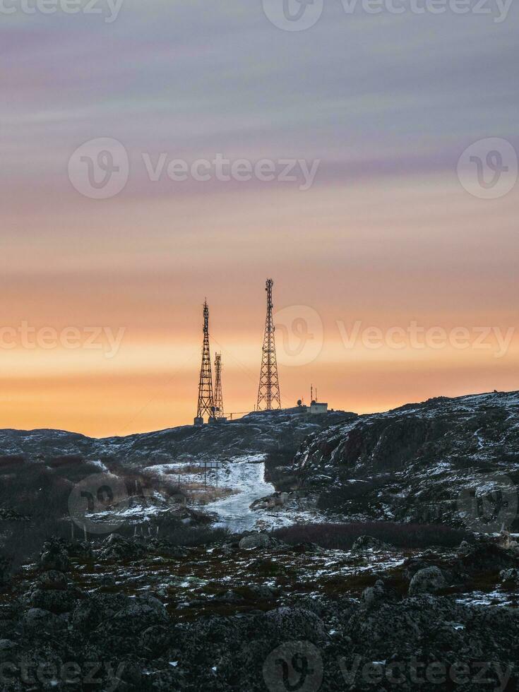 cell torn i de snötäckt kullar i tundra. skön solnedgång kuperad landskap av de arktiska. foto