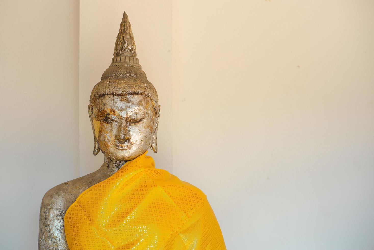 närbild öga och ansikte av gyllene buddha staty belagd med det gyllene bladet i buddhism templet foto