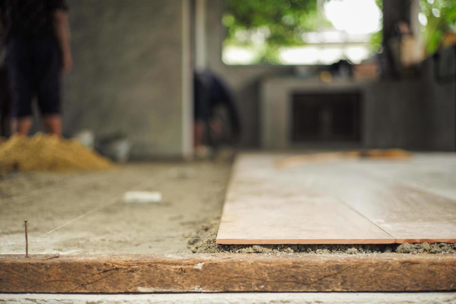 golvplattor för närbild på det blandade cementet med nylon för planering i huset under konstruktion foto
