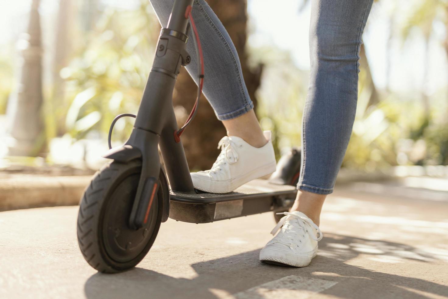 närbild av en person på en elektrisk skoter foto