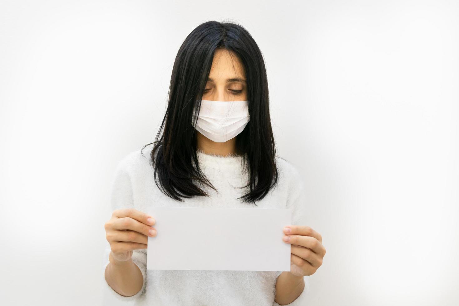 kvinna i en mask som håller ett tomt tecken foto