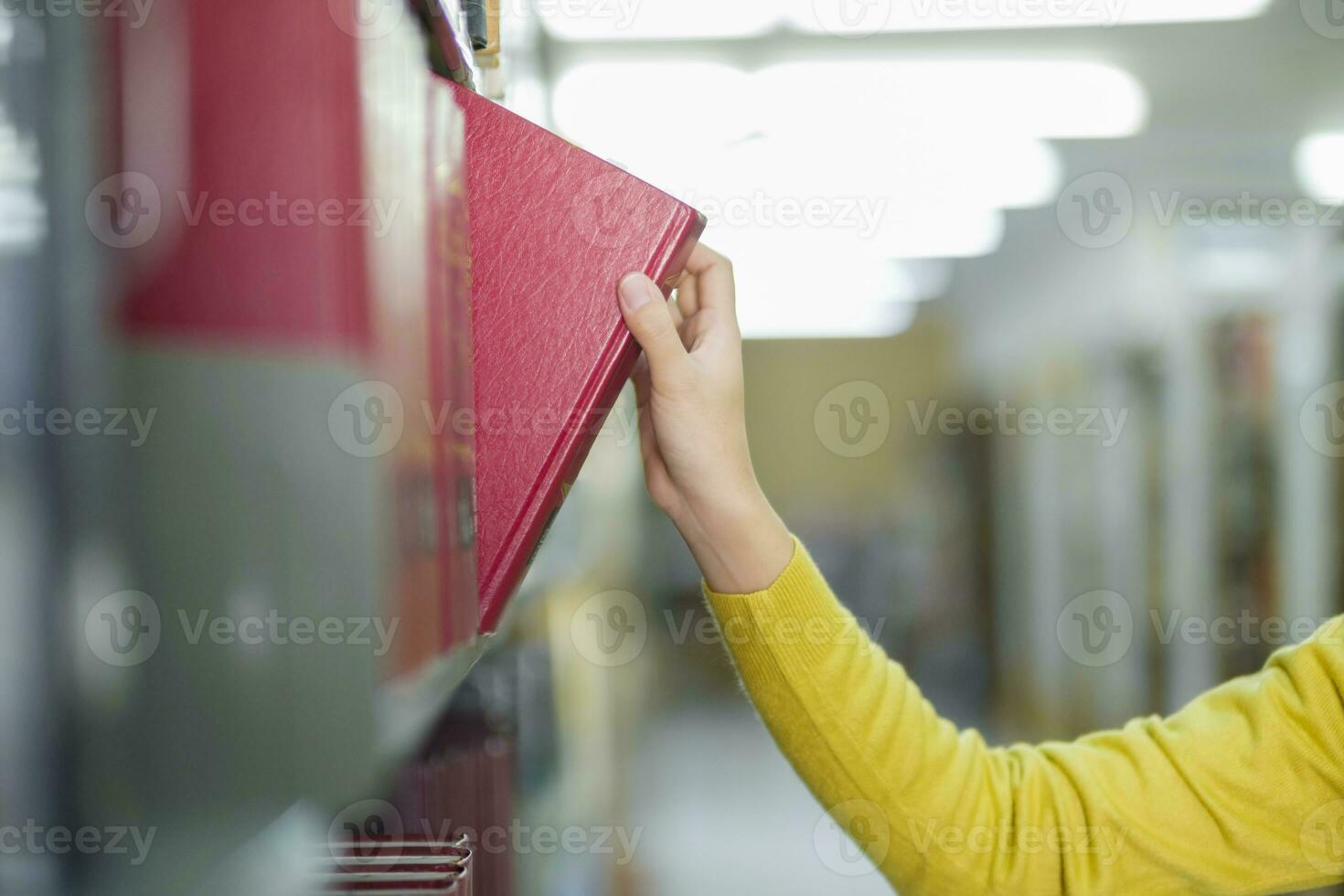 studerande välja och läsning bok på bibliotek. foto