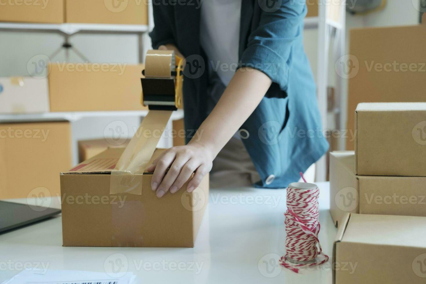 ung kvinna förpackning produkt i låda för uppkopplad ordning. foto