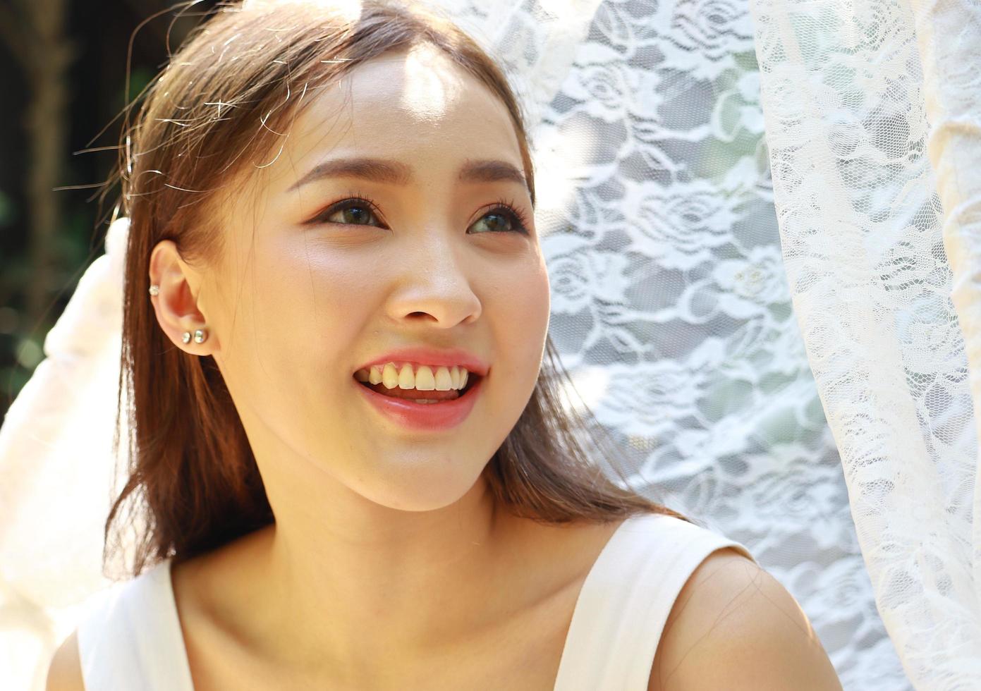 porträtt av vacker ung asiatisk kvinna med rent charmigt leende foto