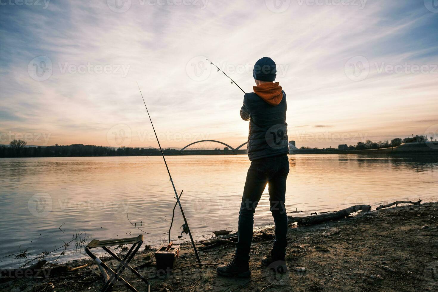 en pojke är fiske på solig vinter- dag foto