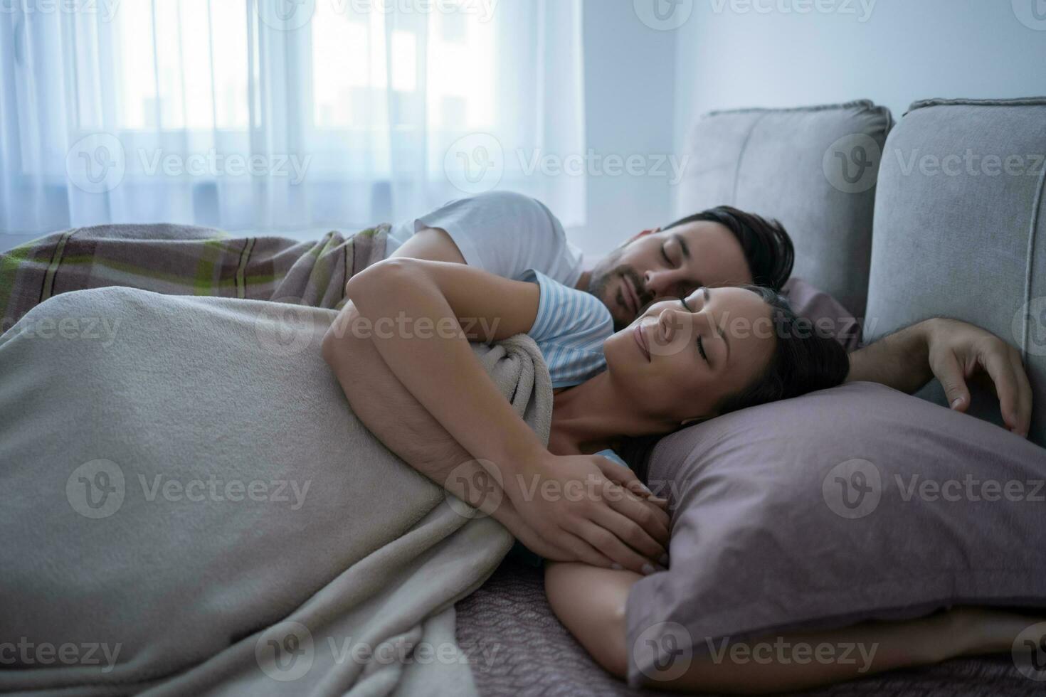 en ung par liggande i säng foto