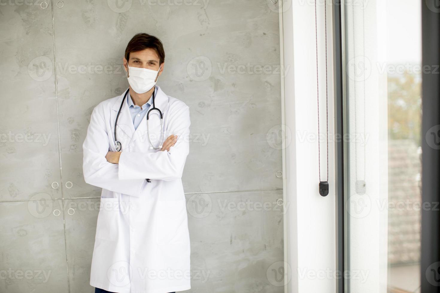 läkare nära ett fönster medan du bär en mask foto