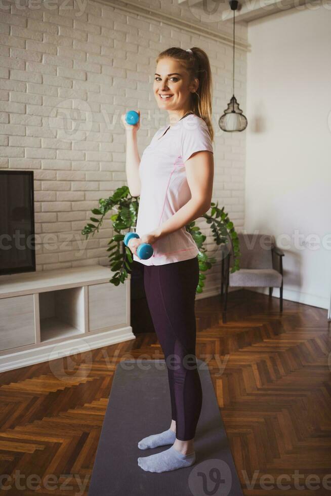 ung kvinna håller på med fysisk övningar på Hem foto