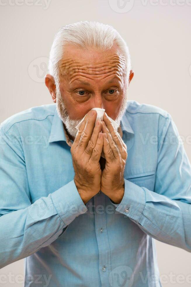 senior man blåser hans näsa foto
