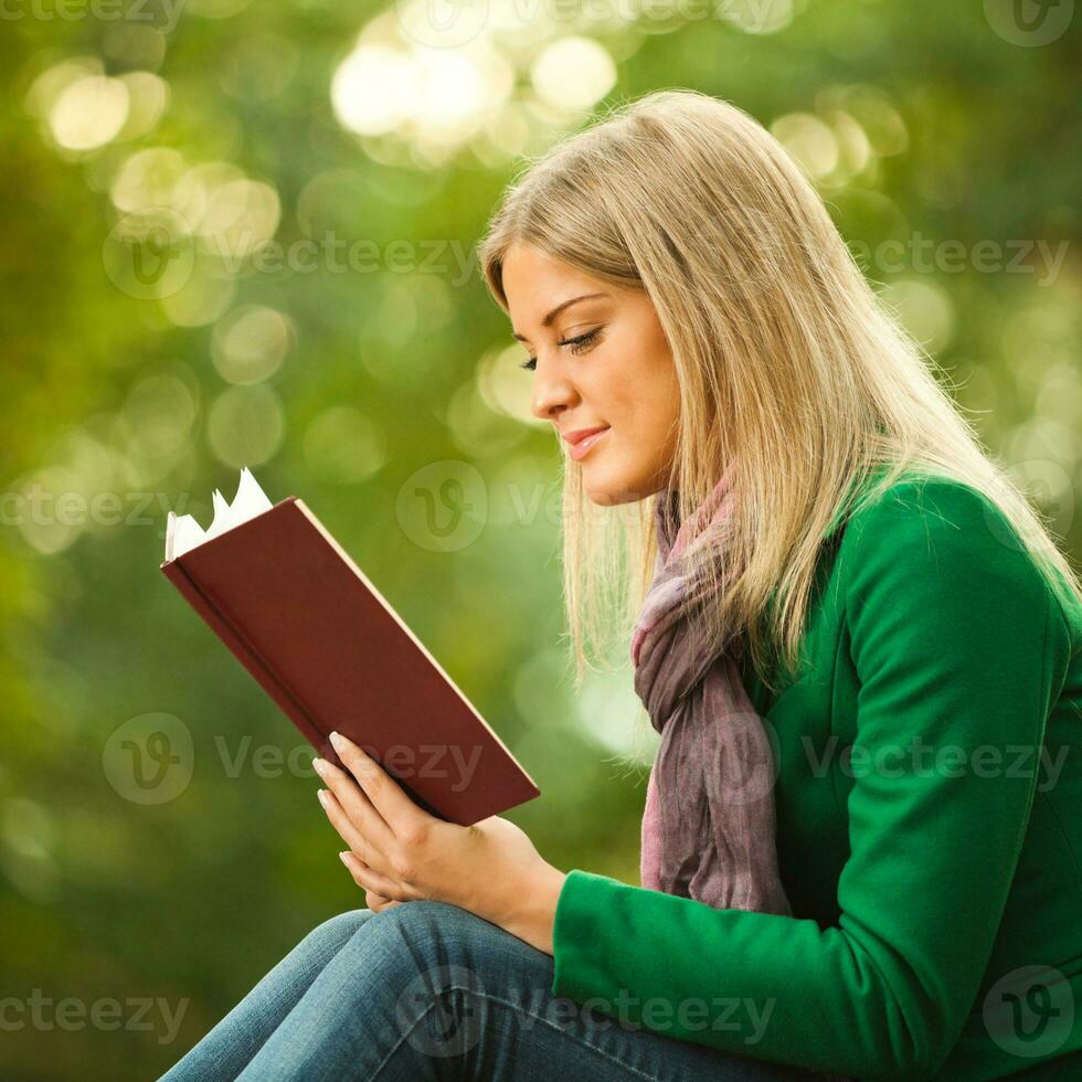 en kvinna läsning en bok foto