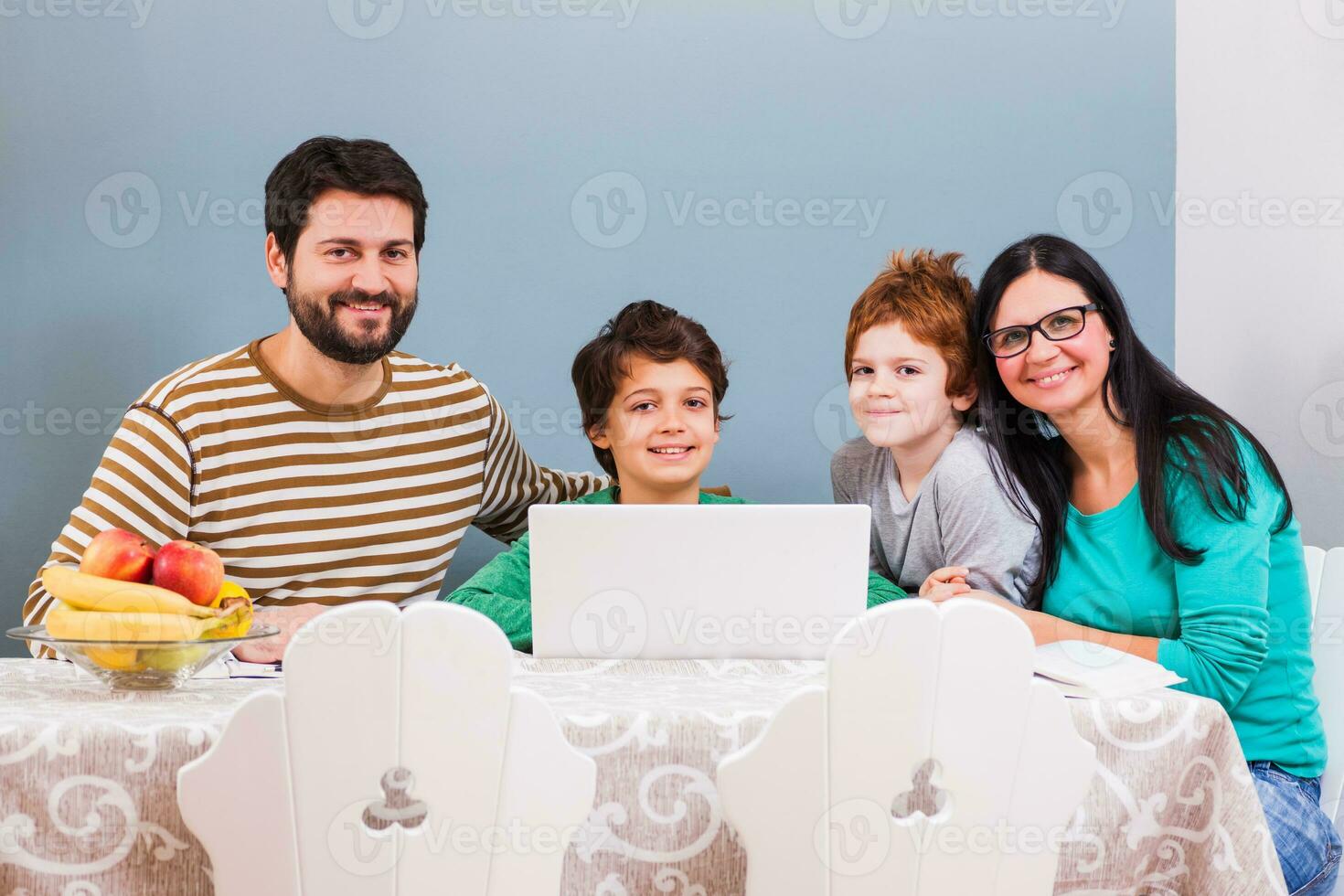 föräldrar är undervisning deras barn till använda sig av de bärbar dator foto