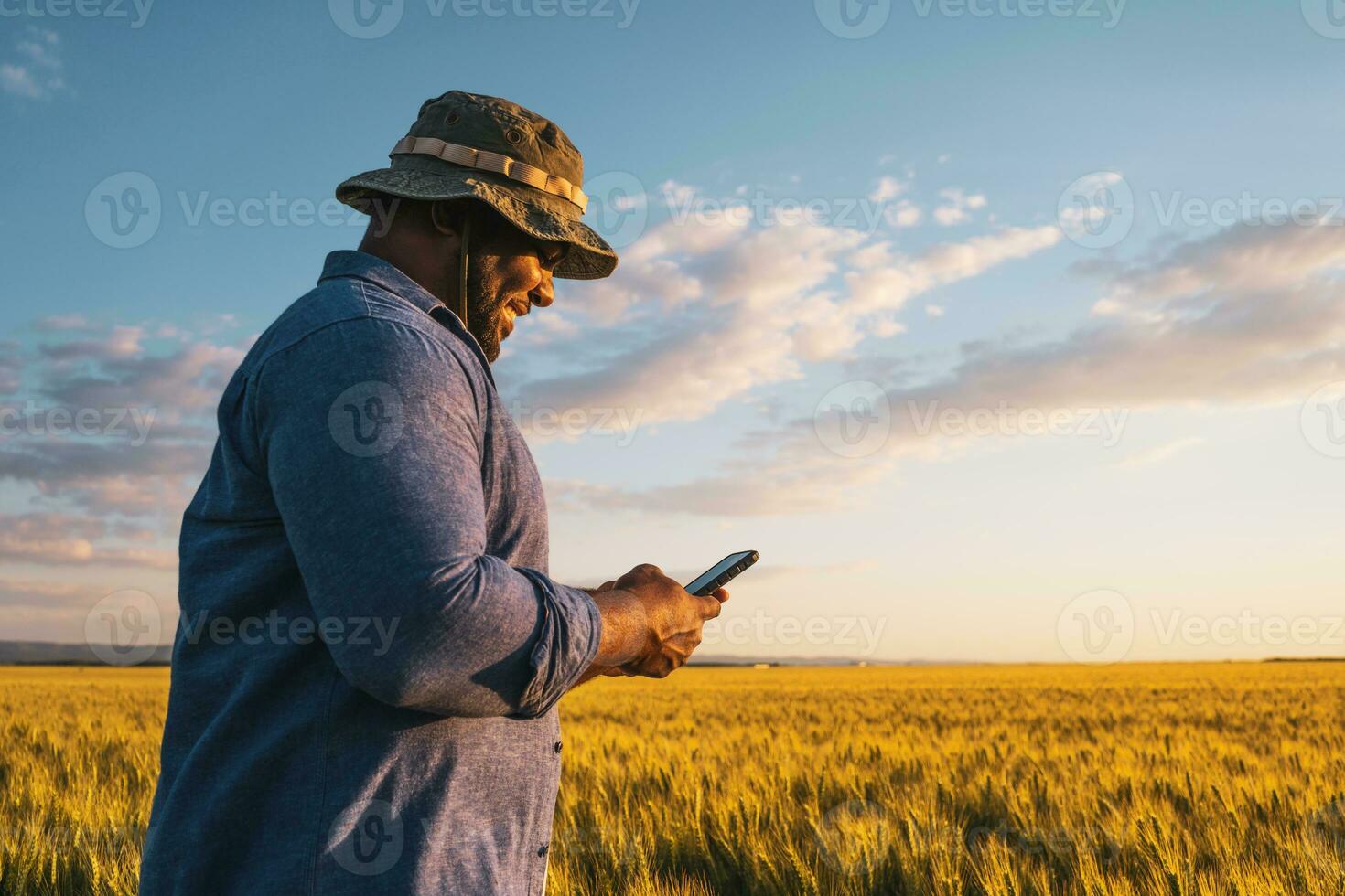 afro jordbrukare stående i en vete fält foto