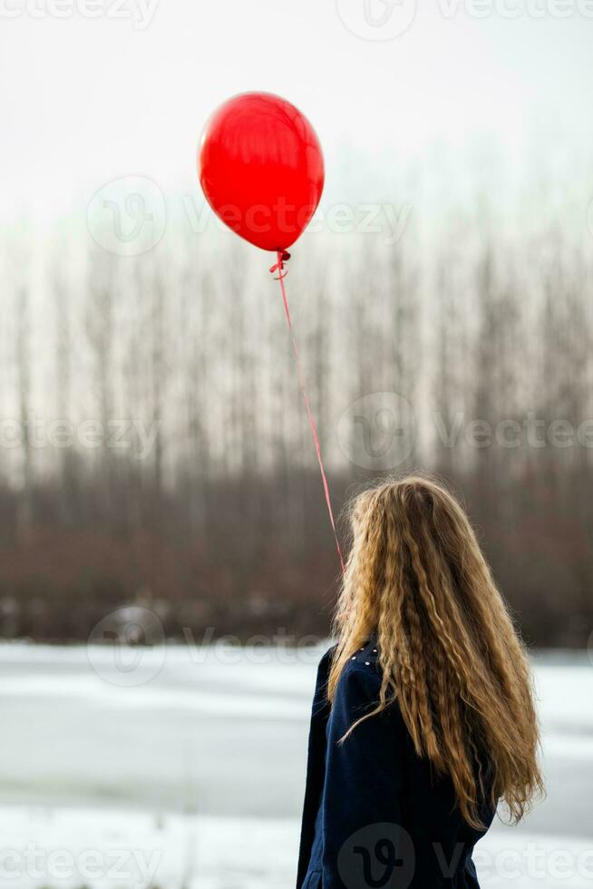 en kvinna med en röd ballong foto