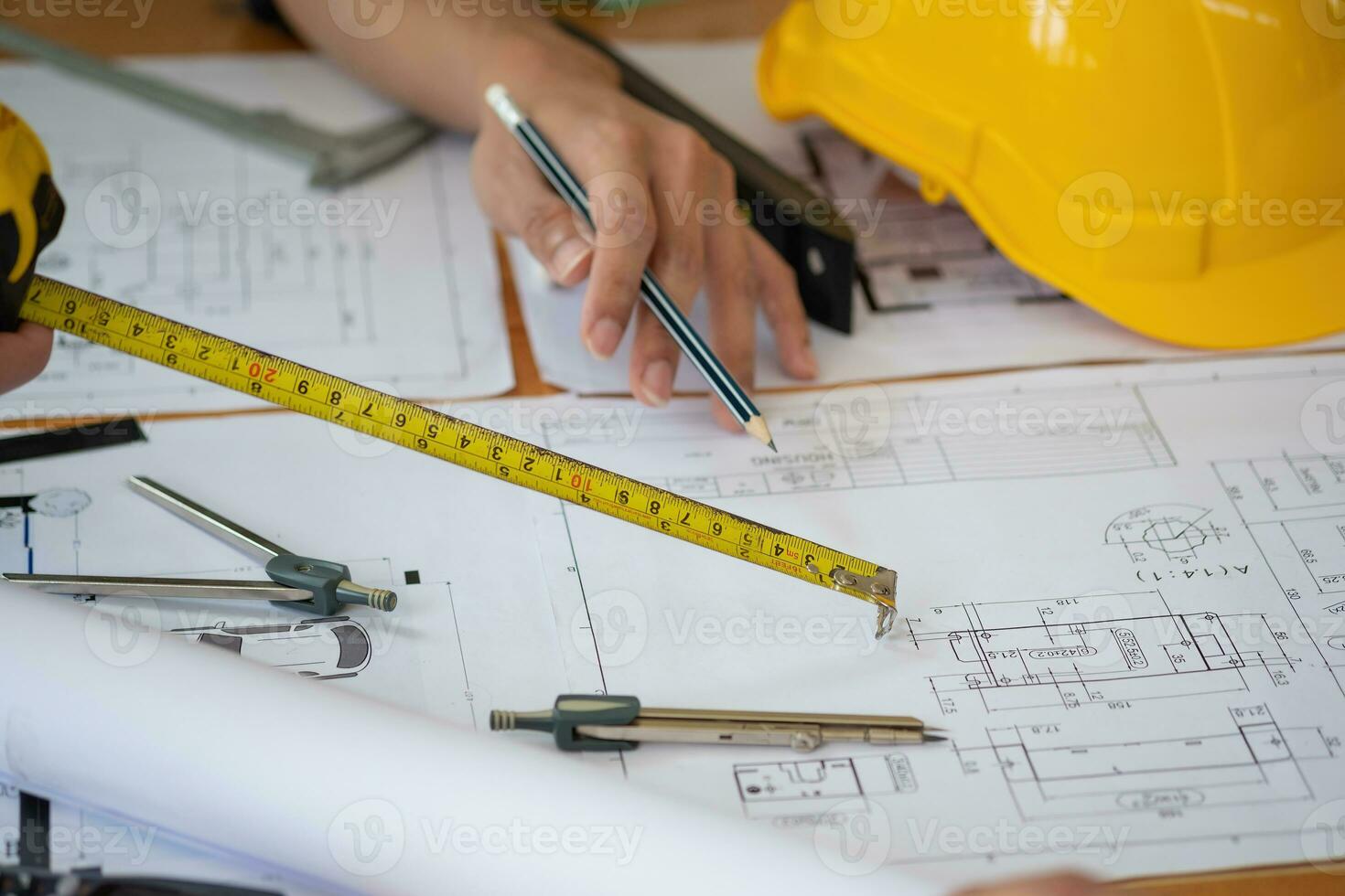 asiatisk ingenjörer spåna och mäta till dokumentera kosta uppskattningar och skriva golv planer för arkitektonisk och teknik mönster för hus och byggnader. foto