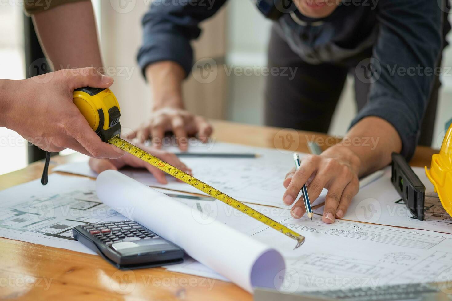 asiatisk ingenjörer spåna och mäta till dokumentera kosta uppskattningar och skriva golv planer för arkitektonisk och teknik mönster för hus och byggnader. foto