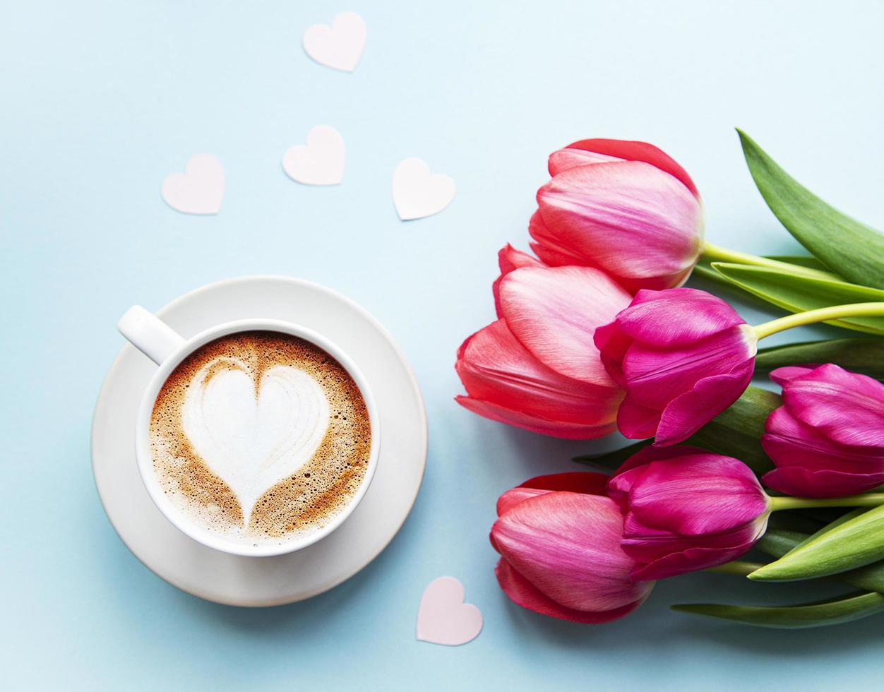 kaffekopp med lattekonst och tulpaner foto