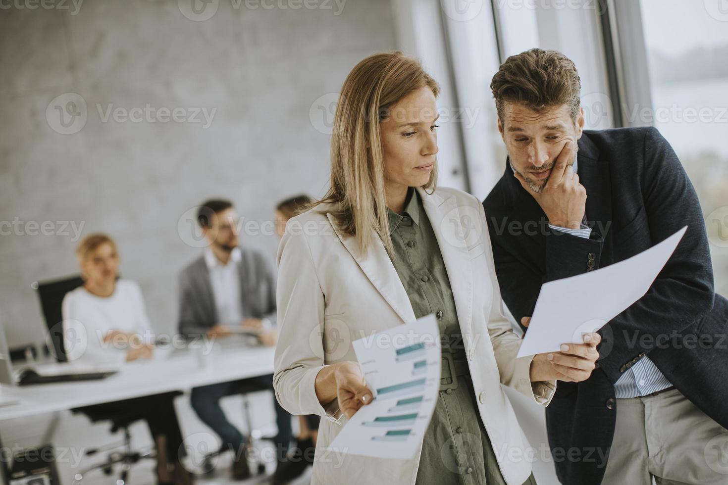 yrkesverksamma som diskuterar dokument foto