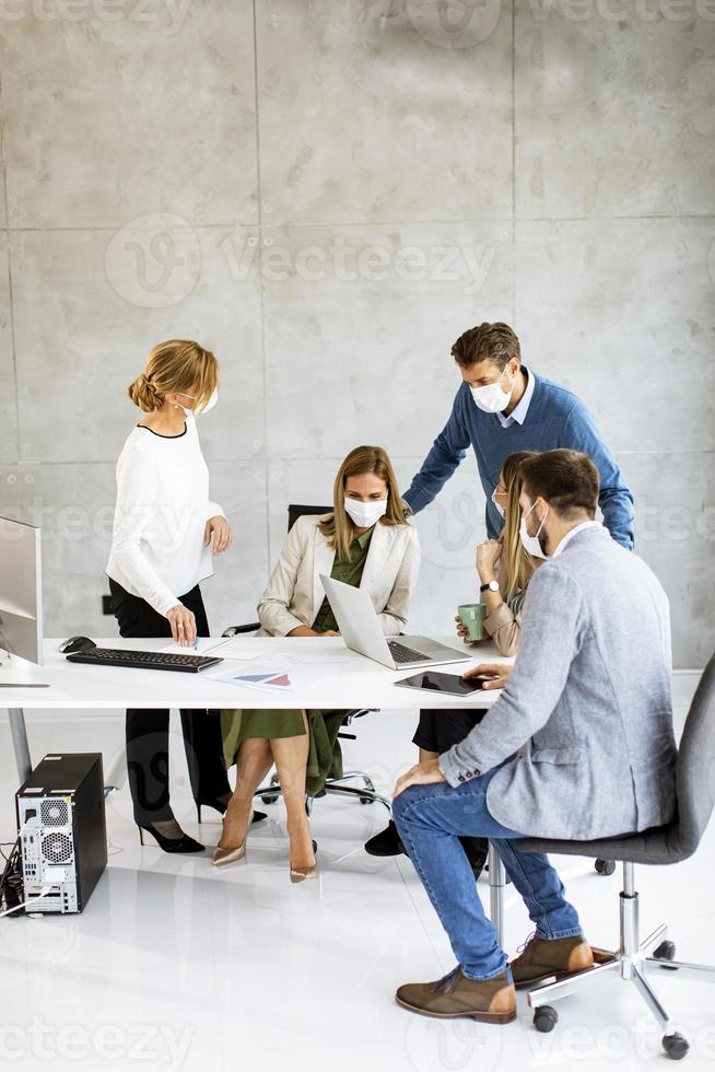 vertikal vy av en grupp i ett möte som bär masker foto