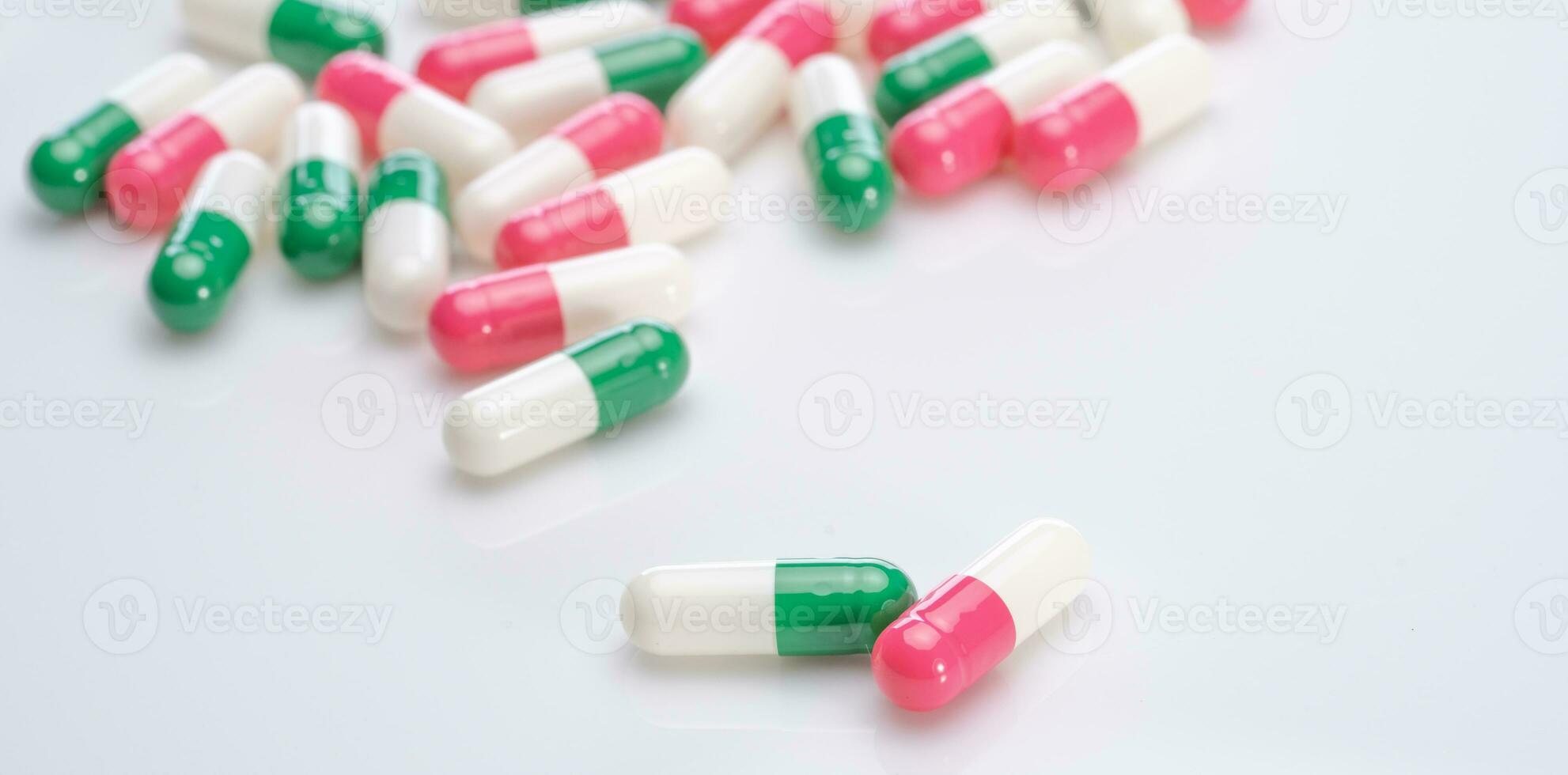 kapslar piller spridning på vit bakgrund. recept läkemedel. kapsel piller produktion. grön, rosa, och vit Färg kapsel piller. farmaceutisk industri. medicin och farmakologi. hälsa vård. foto