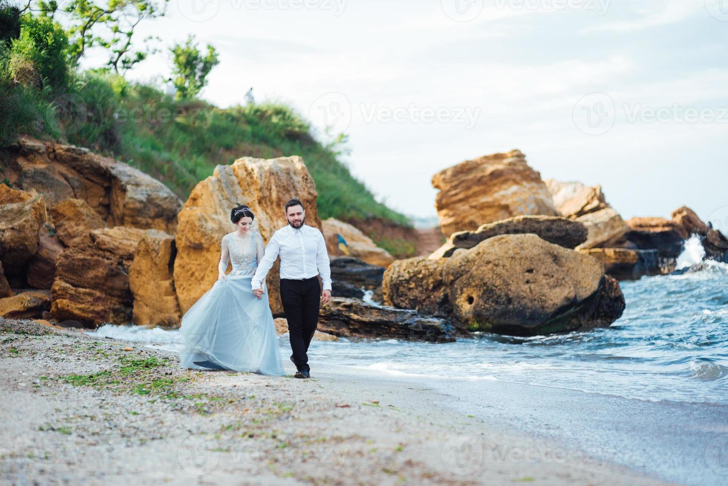 samma par med en brud i en blå klänning promenad foto