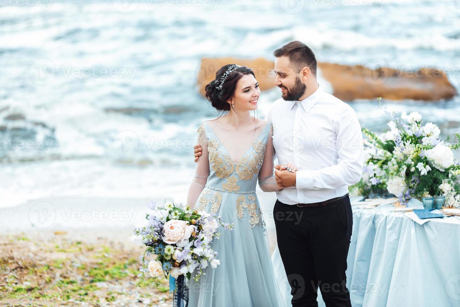 samma par med en brud i en blå klänning promenad foto