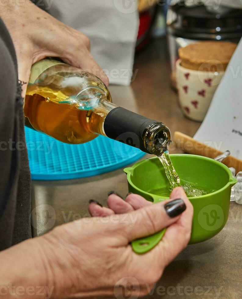 kock häller vin in i en maträtt till Lägg till till de måltid foto