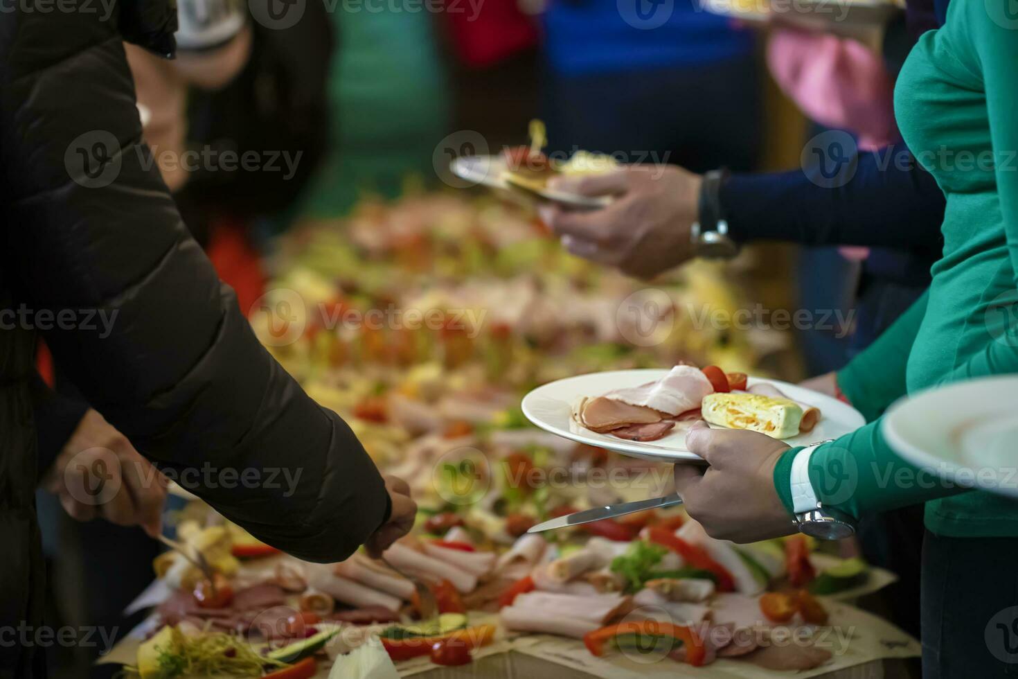 buffé. händer med en tallrik på de bakgrund av en tabell med mat. foto