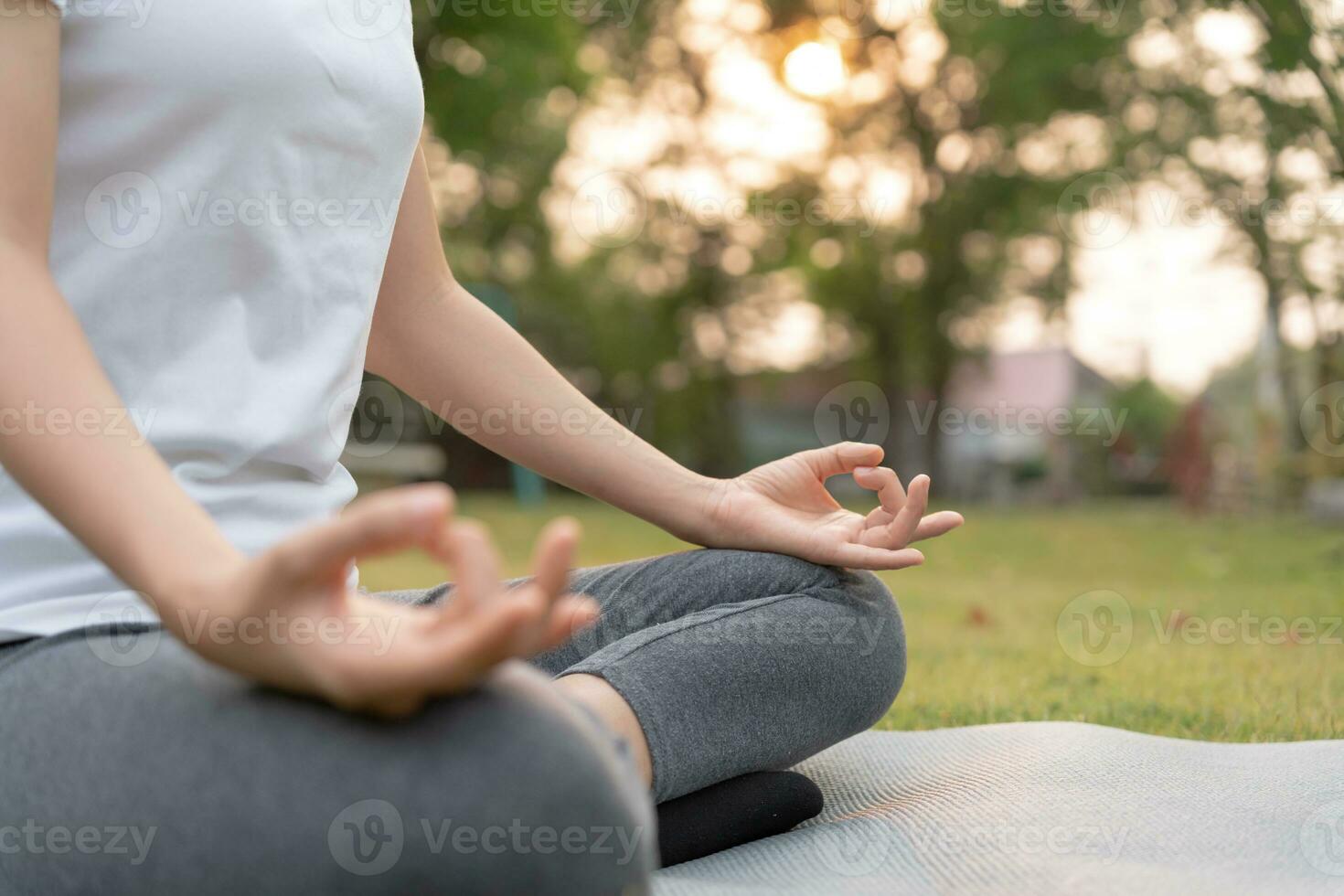 kvinna praktiserande meditera på de parkera. asiatisk kvinna håller på med övningar i morgon. balans, rekreation, avslappning, lugna, Bra hälsa, Lycklig, koppla av, friska livsstil, minska påfrestning, fredlig, attityd. foto