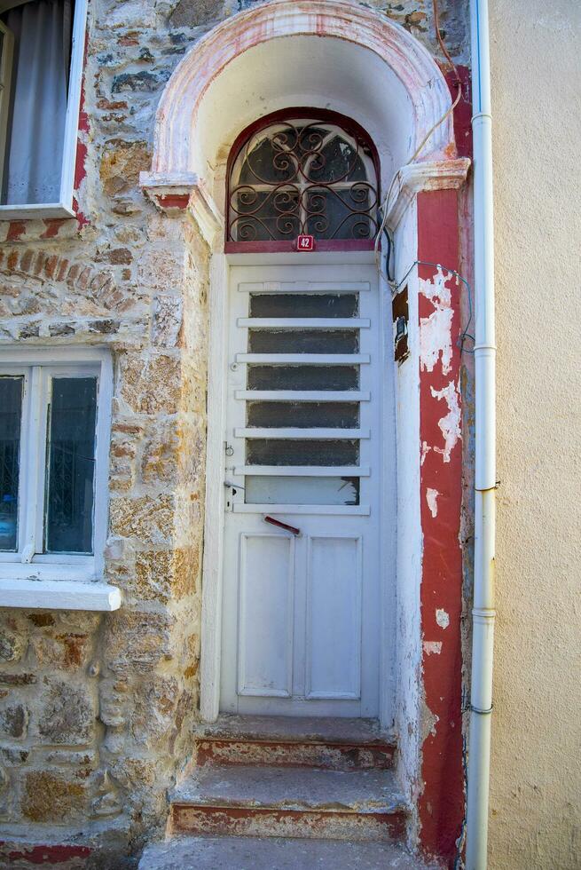 en vit smal dörr i en turkiska hus med ett båge och en fönster. foto