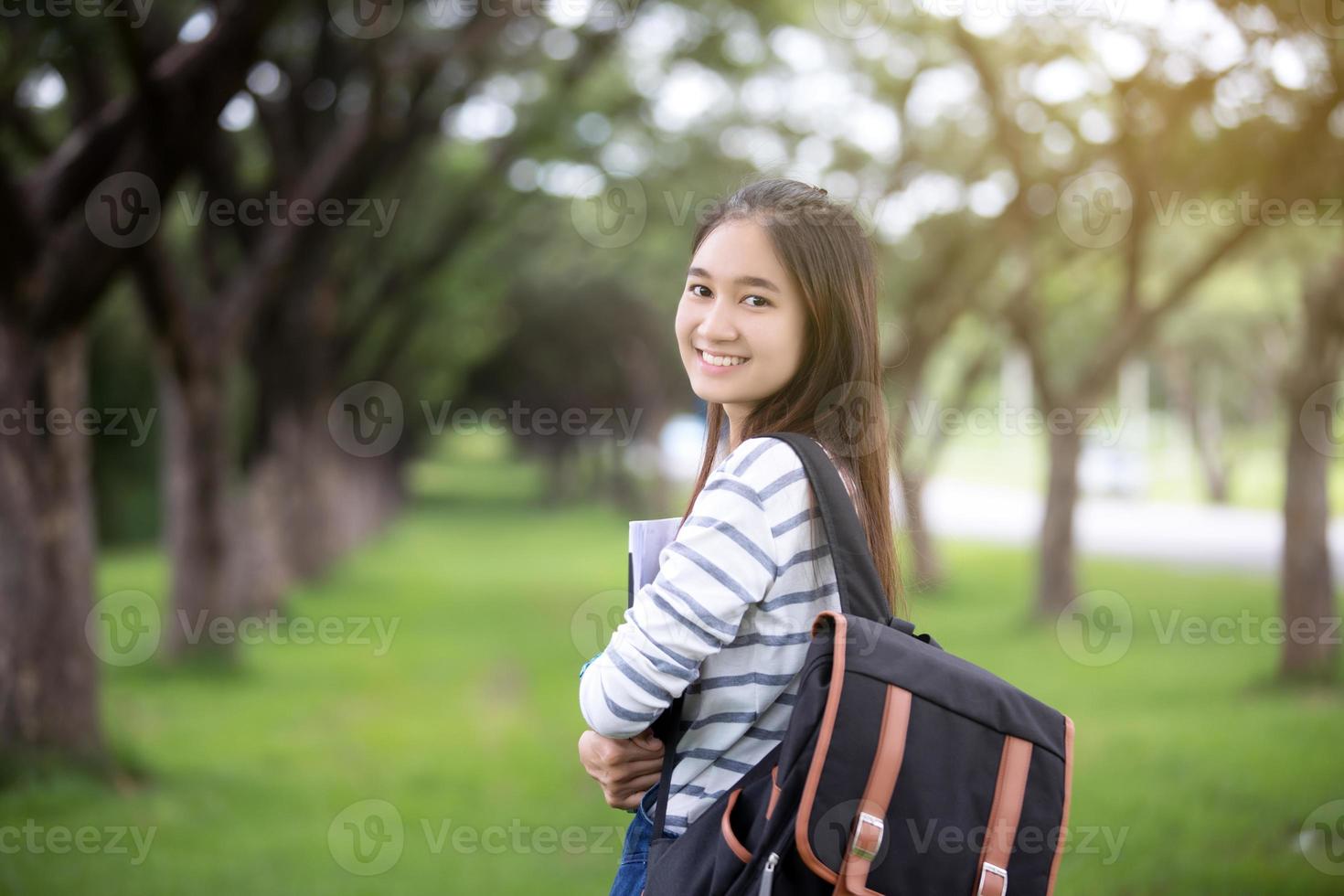 ung asiatisk student som bär ryggsäck foto