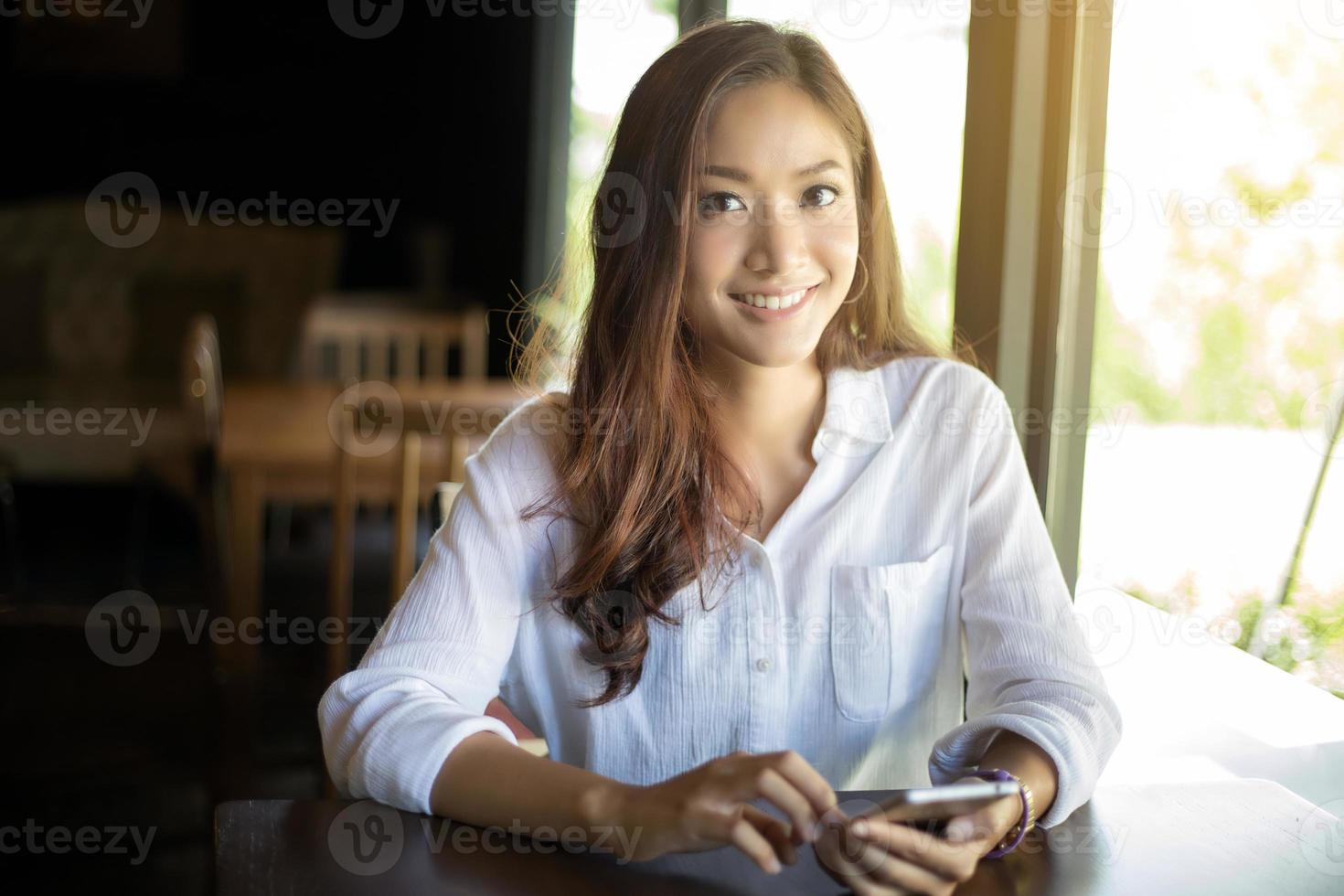 kvinna som använder smart telefon på ett kafé foto