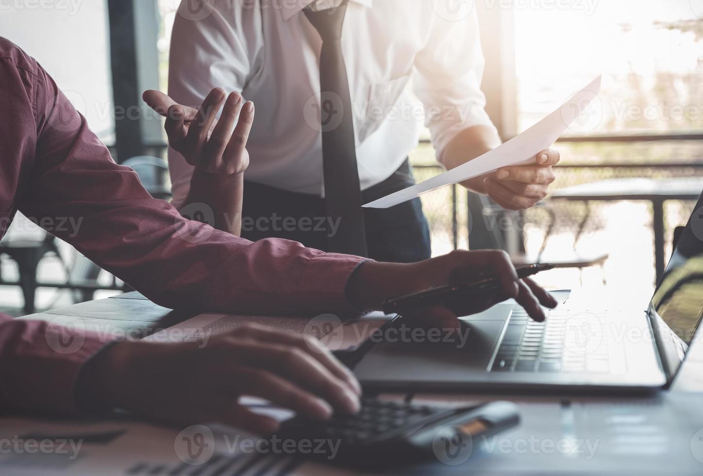 ekonomiska forskningsdiskussioner, affärsteam som analyserar inkomstdiagram och diagram för att planera marknadsföringskoncept med användning av bärbar dator och miniräknare för analys. foto