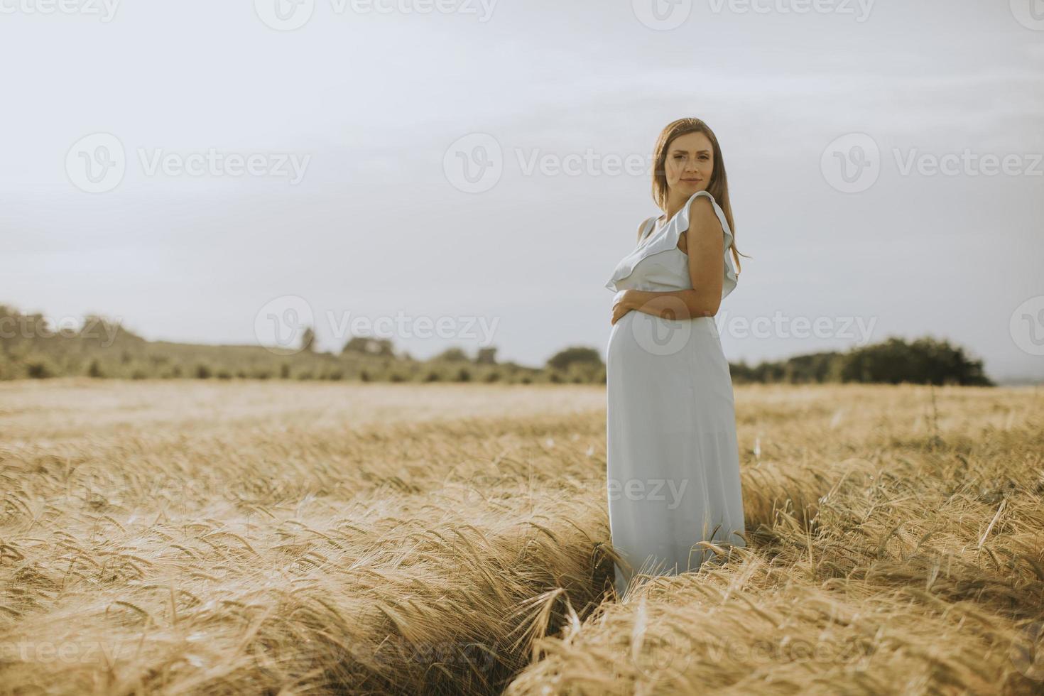 ung gravid kvinna i vit klänning foto