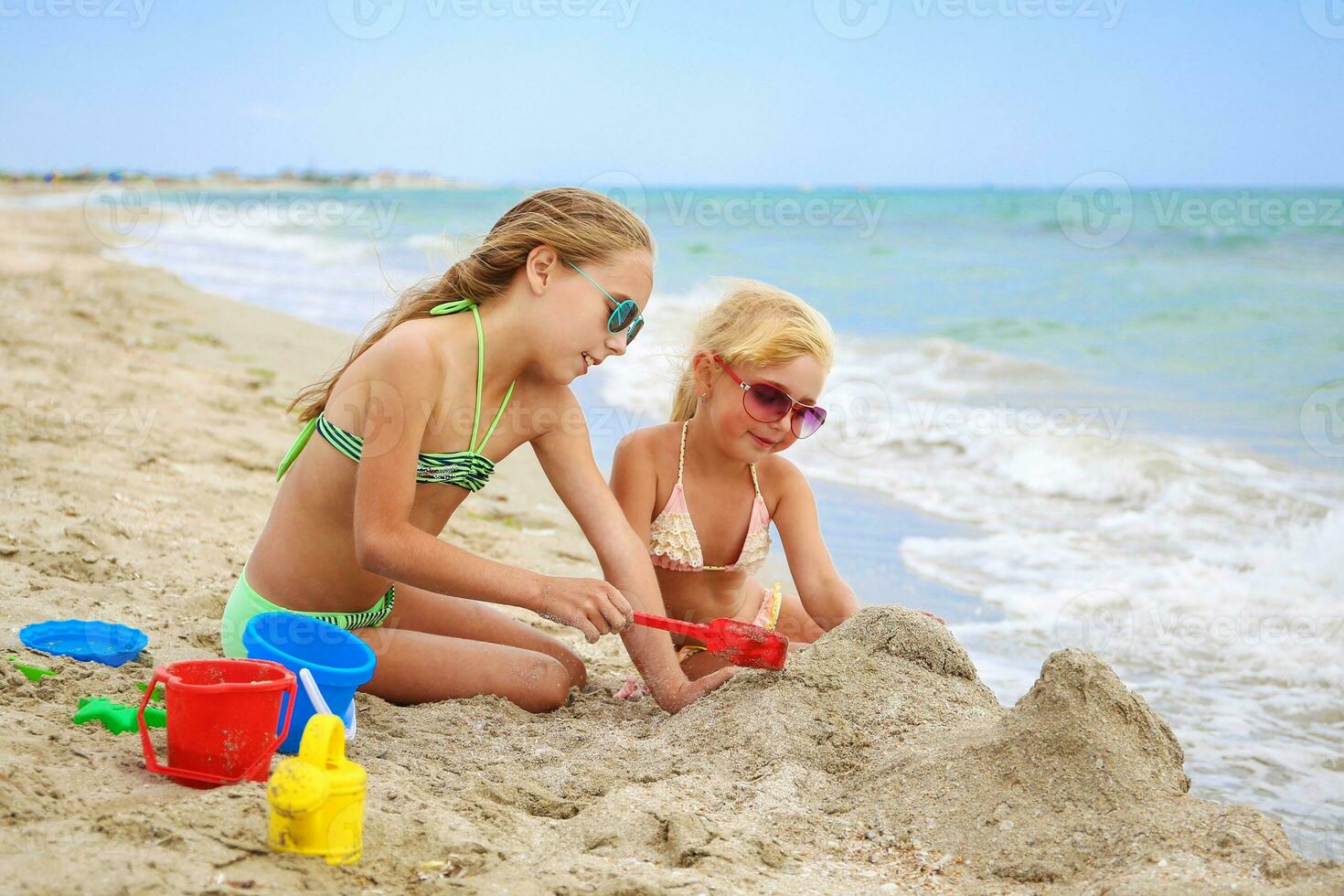 barn spela med sand på strand. foto