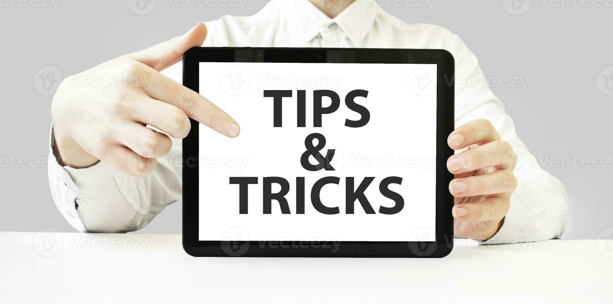 text tips och knep på läsplatta visa i affärsman händer på de vit bakgrund. företag begrepp foto