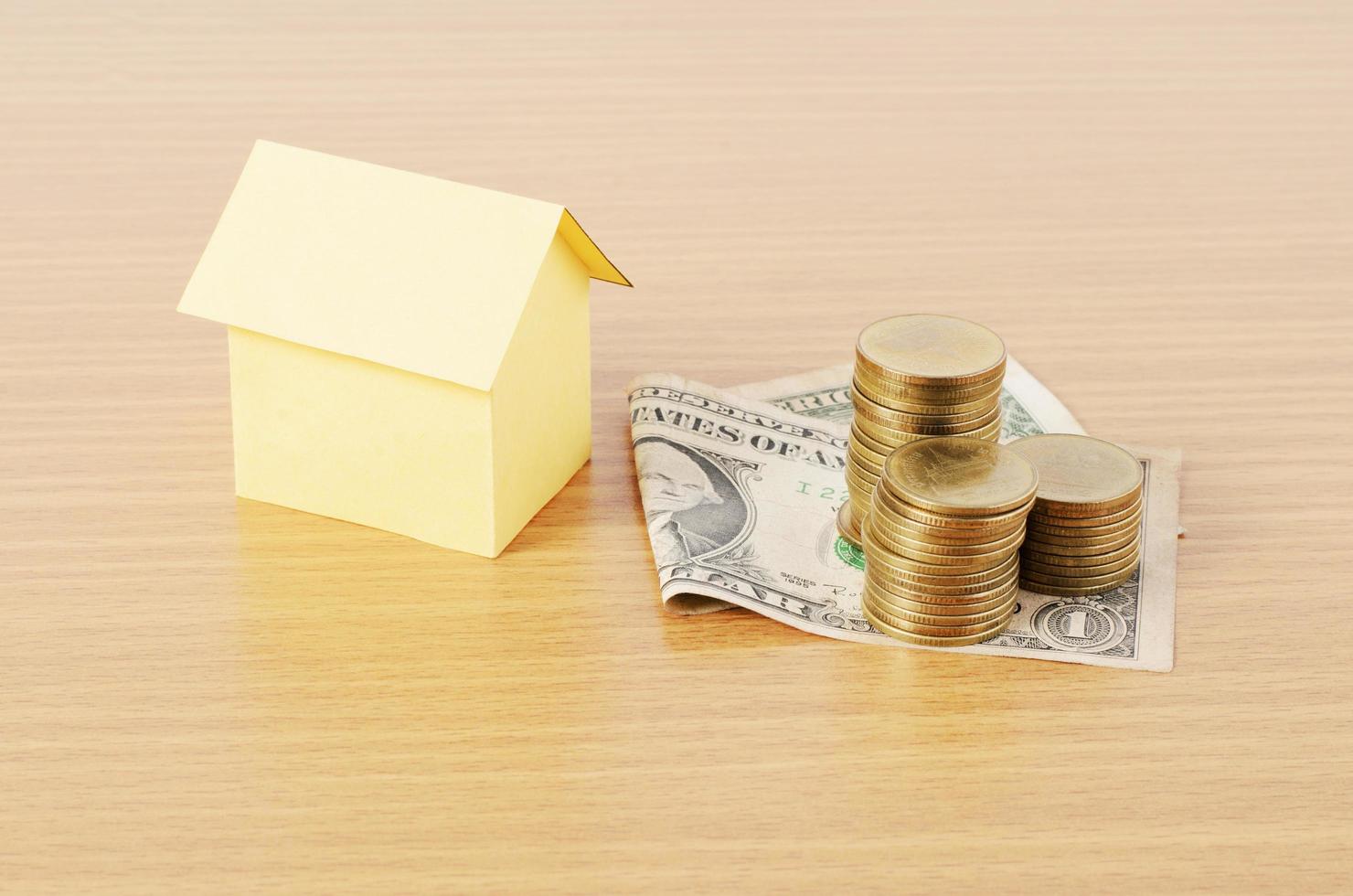 bostadslån koncept med dollar pengar och mynt stack på trä skrivbord bakgrund foto