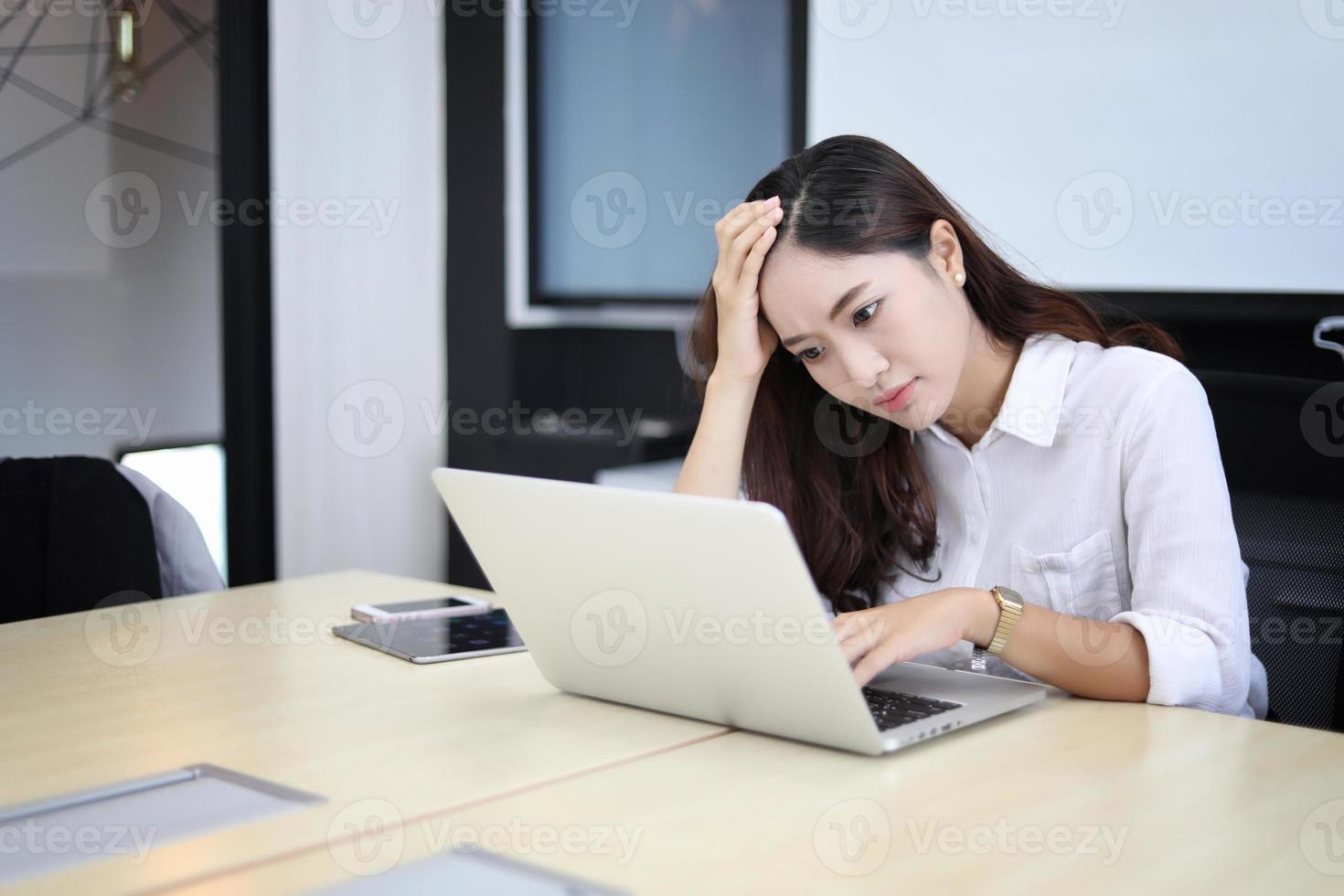 kvinna som arbetar på en dator, känner stress foto