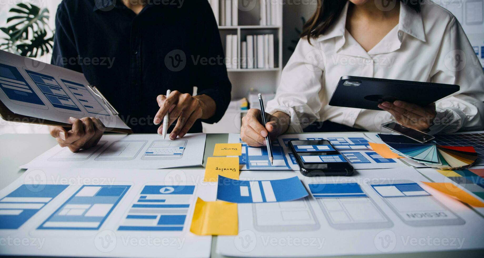 stänga upp ux utvecklare och ui designer brainstorming handla om mobil app gränssnitt trådmodell design på tabell med kund kortfattat och Färg koda på modern office.creative digital utveckling byrå foto