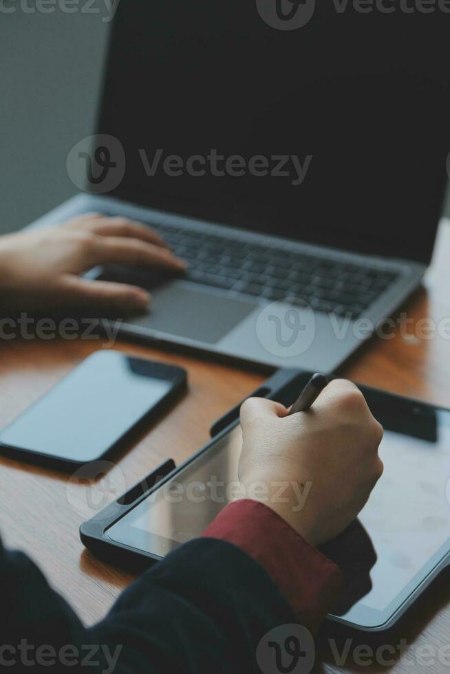 Asiatisk affärskvinna som använder bärbar dator och arbetar på kontoret med kalkylatordokument på skrivbordet, planerar att analysera den finansiella rapporten, affärsplansinvesteringar, finansanalyskoncept. foto