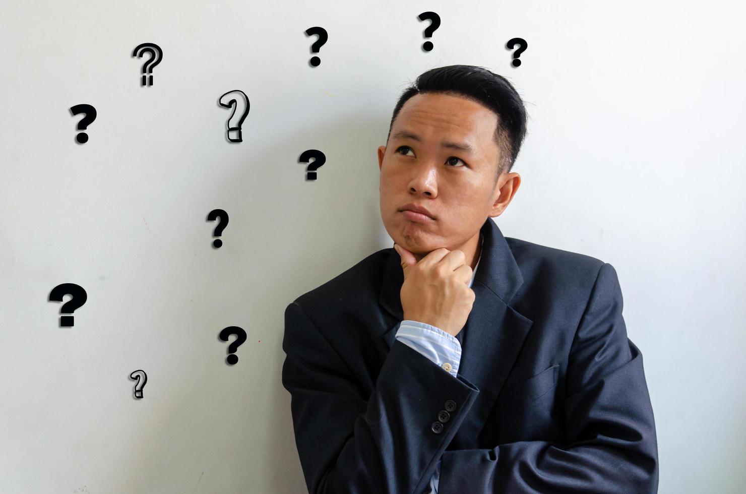 asiatisk affärsman med ett frågetecken. konceptaffär. foto
