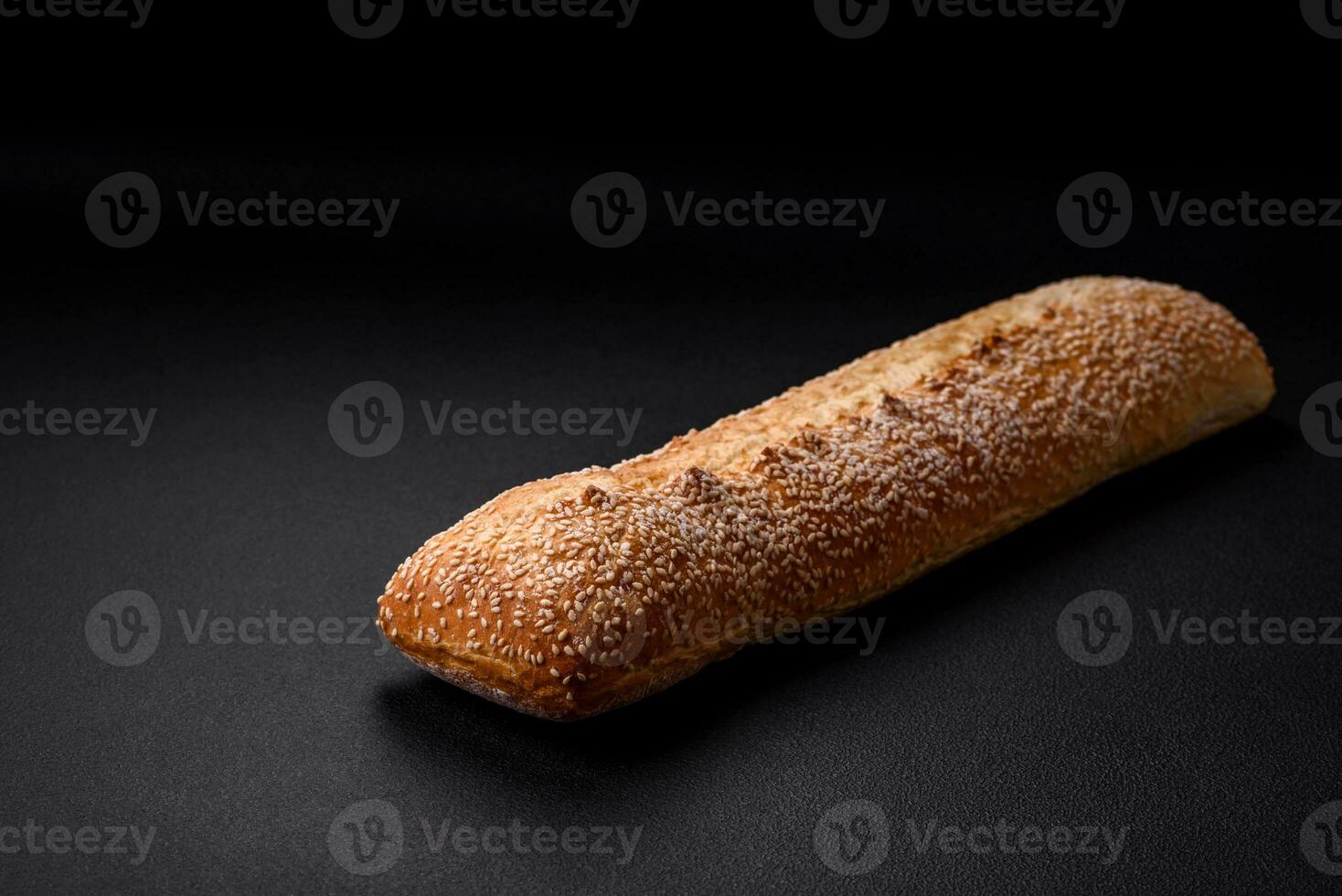 Krispig vete mjöl baguette med sesam frön på en trä- skärande styrelse foto