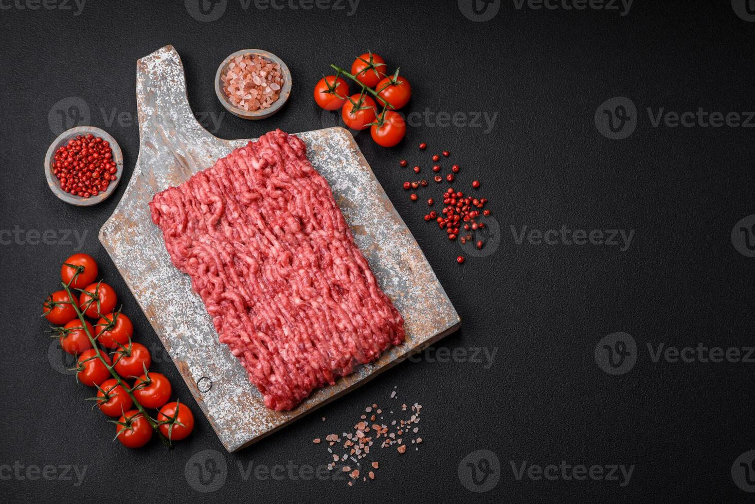 rå jord nötkött eller fläsk på en trä- skärande styrelse med kryddor och salt foto