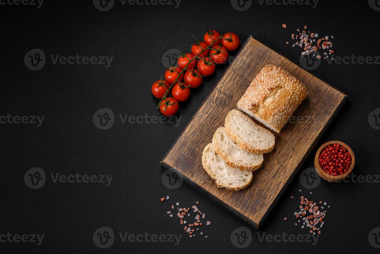 Krispig vete mjöl baguette med sesam frön på en trä- skärande styrelse foto