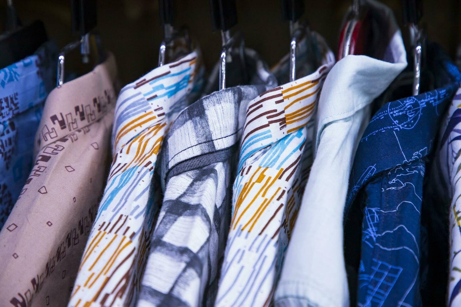 färgrik mängd av shirts hängningar i en Kläder showroom. kluster fokus foto