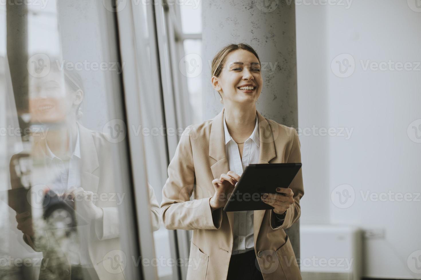 kvinna som står med en tablett foto