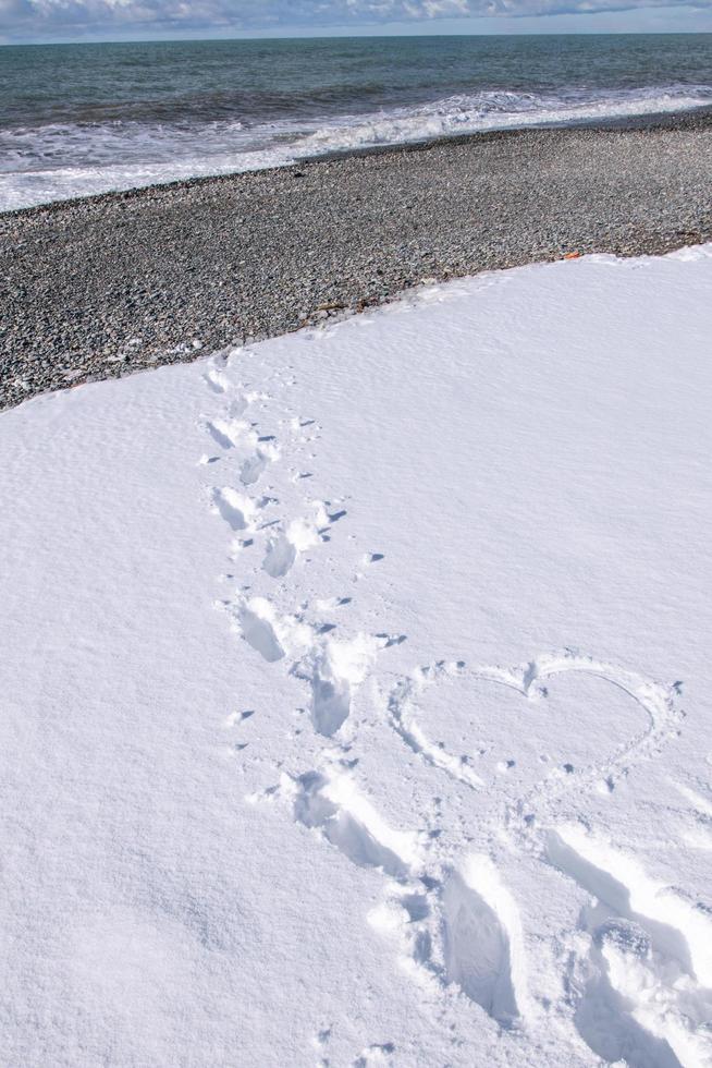 steg på vit snö som leder till stranden foto